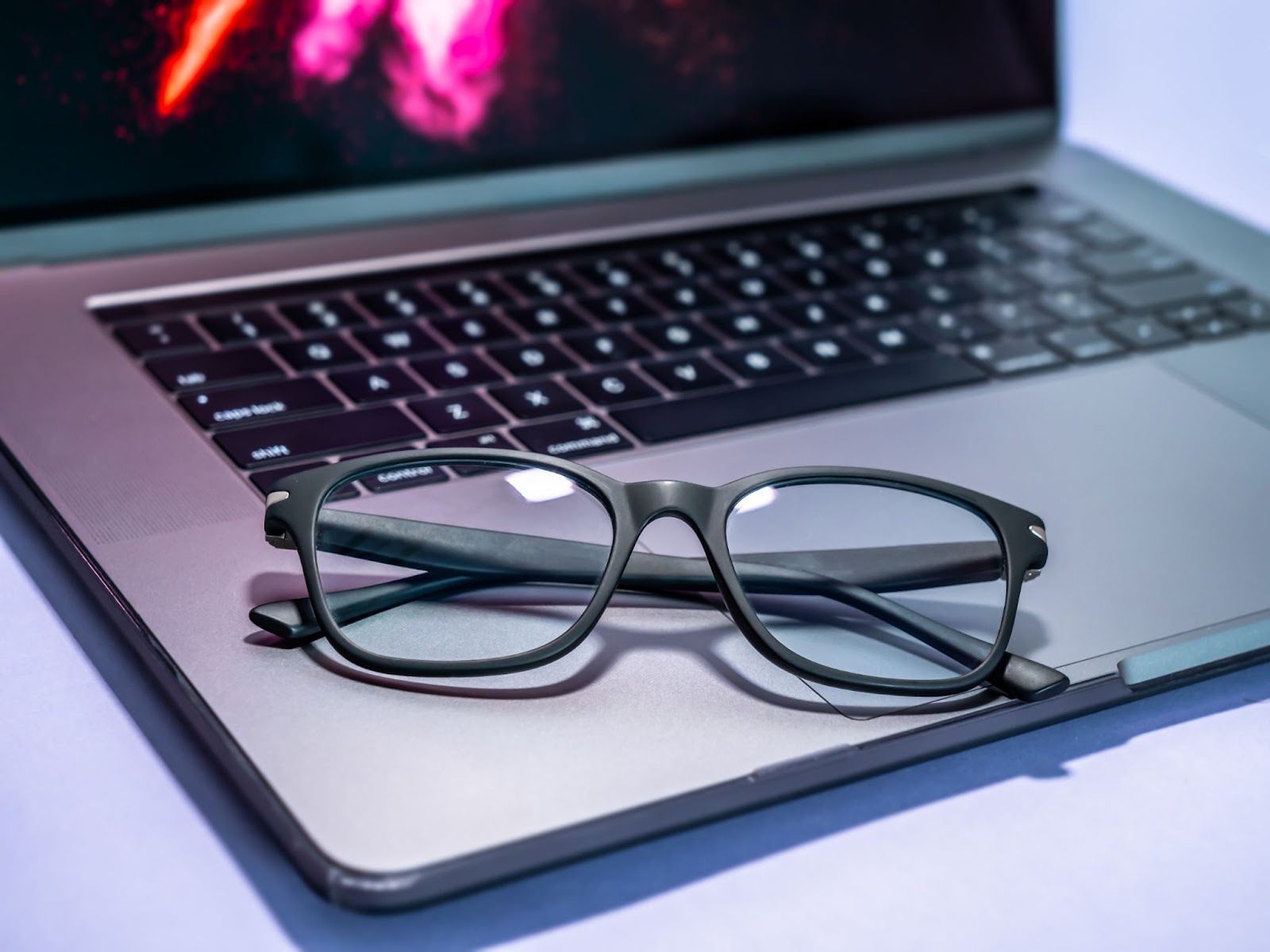 A pair of blue light glasses are placed on a laptop to help with digital eye strain.