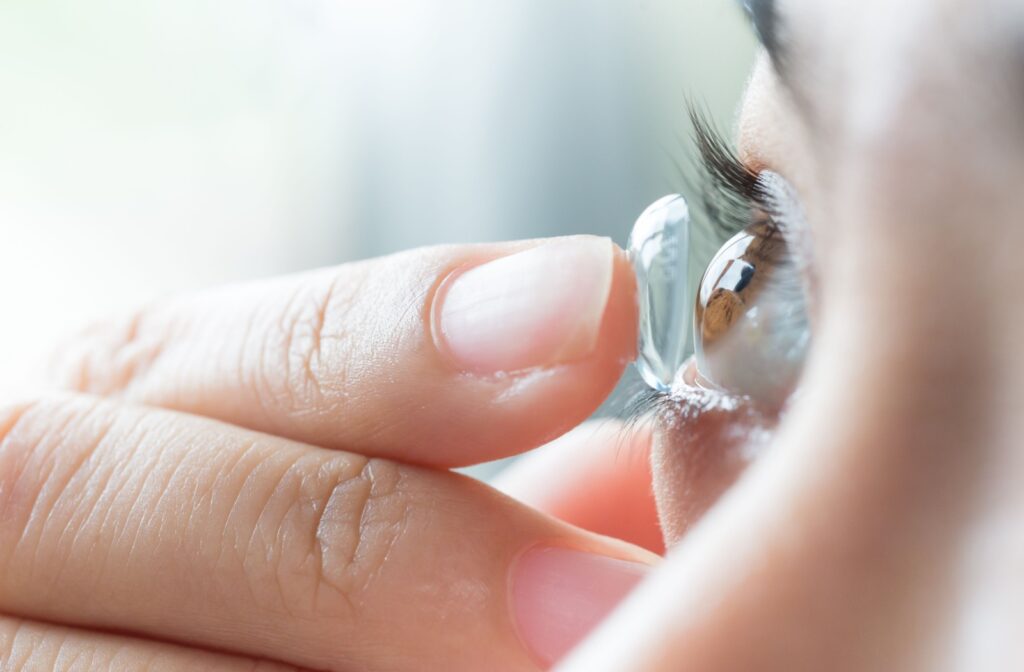 A closeup of a young woman applying her soft toric contact lenses.