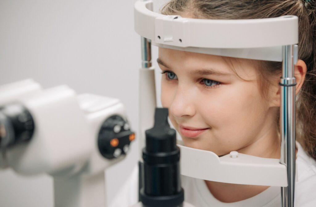 A young girl undergoing an eye examination with a slit lamp at an optometrist's office.
