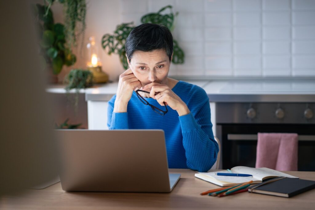 Woman working on her laptop in her kitchen